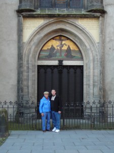 P1050003 At the doorway of the castle church in Wittenburg where Luther nailed the 95 theses. The original wood doors burned in a fire and were replaced with these bronze doors with the 95 theses engraved in them.